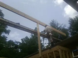 Carpenter setting a ridge beam over a new addition frame — Ice Dam Removal by Roofing Brothers in Kearney